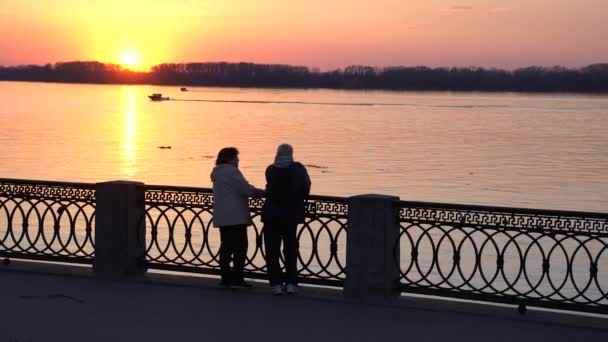 都市の住民は 日没時に大きな川の堤防に就業日の後 アクティブな生活をリードしています — ストック動画