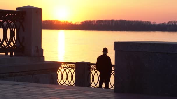 美丽的夕阳在大河上 城市的居民过着积极的生活方式 在日落后的大河堤上工作了一天 从最后一次的水中反射黄金 — 图库视频影像