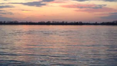 Büyük nehirde güzel gün batımı , son gelen su altın yansımaları