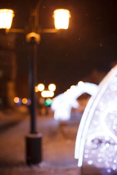 Night walk around the city. Decoration of streets with garlands and lanterns.