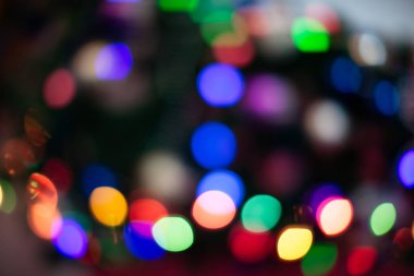 Noel ağacı farklı renklerde aydınlatılmıştır. Yeni yıl tatilinde bulanık arka plan