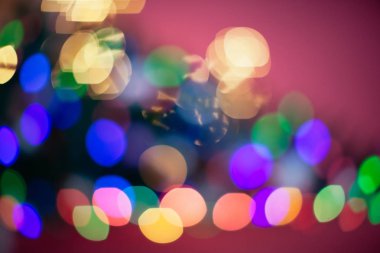 Noel ağacı farklı renklerde aydınlatılmıştır. Yeni yıl tatilinde bulanık arka plan