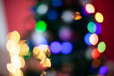 Noel ağacı farklı renklerde aydınlatılmıştır. Yeni yıl tatilinde bulanık arka plan