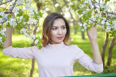çiçekli kız. bahar bahçesinde muhteşem bir model. Baharda ağacın yanındaki kız. bahar kavramı.
