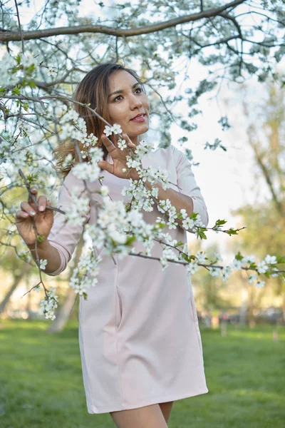 girl with flowers. gorgeous model in the spring garden. the girl near the tree in the spring. the concept of spring. young orchard