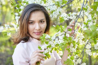 çiçekli kız. bahar bahçesinde muhteşem bir model. Baharda ağacın yanındaki kız. bahar kavramı.