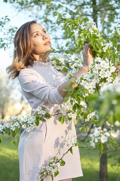 girl with flowers. gorgeous model in the spring garden. the girl near the tree in the spring. the concept of spring.