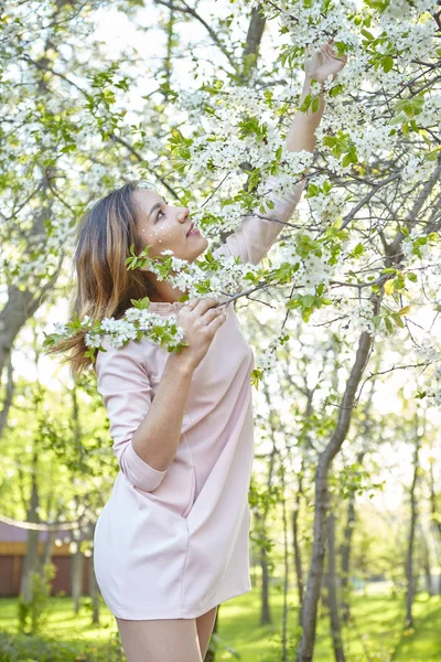 Girl with flowers. gorgeous model in the spring garden. the girl near the tree in the spring. the concept of spring. — Stock Photo, Image