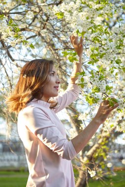 çiçekli kız. bahar bahçesinde muhteşem bir model. baharda ağacın yanındaki kız.