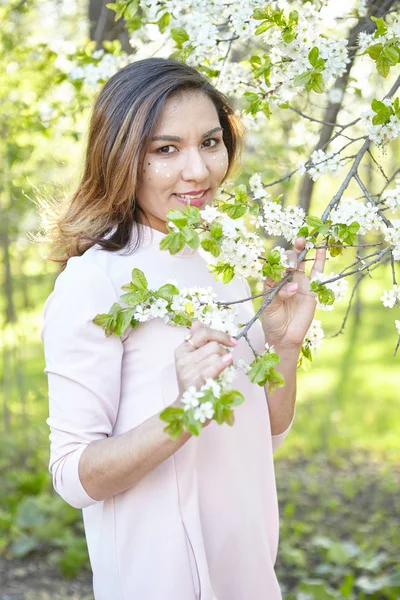 girl with flowers. gorgeous model in the spring garden. the girl near the tree in the spring.