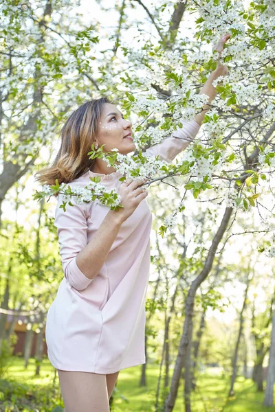 Girl with flowers. gorgeous model in the spring garden. the girl near the tree in the spring. — Stock Photo, Image