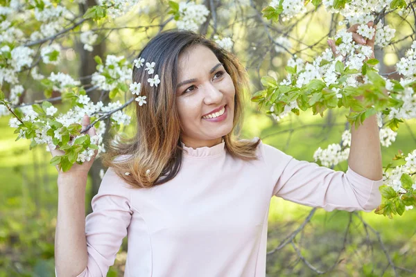 girl with flowers. gorgeous model in the spring garden. the girl near the tree in the spring.