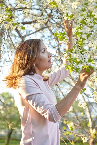 girl with flowers. gorgeous model in the spring garden. the girl near the tree in the spring.