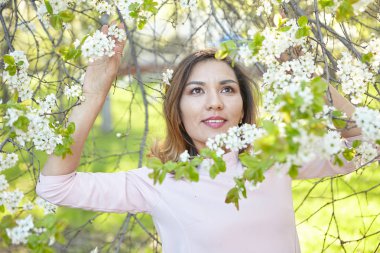 çiçekli kız. bahar bahçesinde muhteşem bir model. Baharda ağacın yanındaki kız. bahar kavramı. genç meyve bahçesi