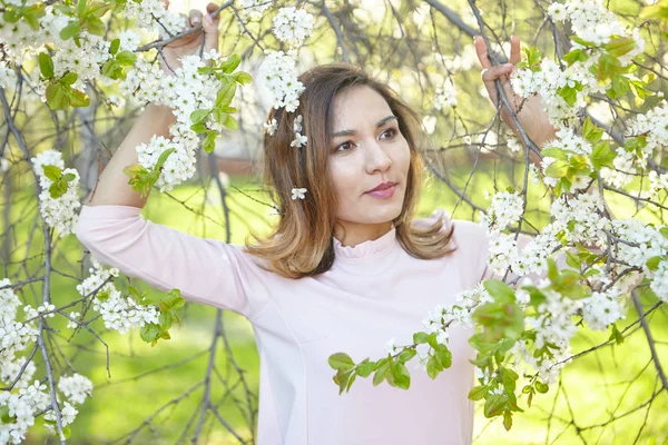 girl with flowers. gorgeous model in the spring garden. the girl near the tree in the spring. the concept of spring. young orchard