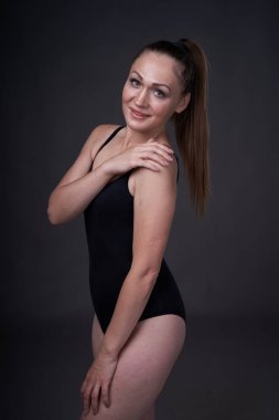 esnek seksi kız uygun giysiler baud siyah gri arka plan üzerinde pozlar