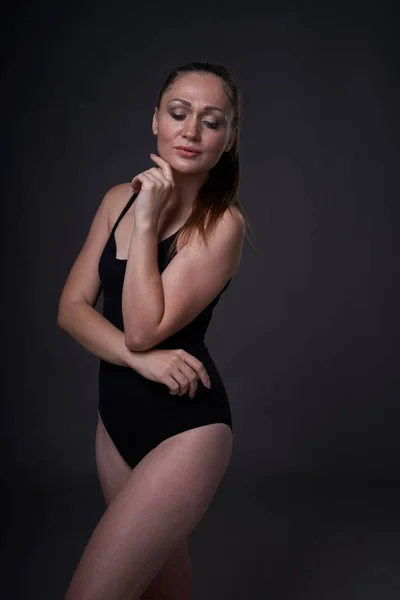 Flexible sexy chica poses en un negro gris fondo en la apropiado ropa baud —  Fotos de Stock