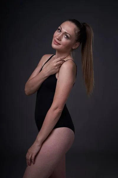 Rugalmas szexi lány jelent a fekete szürke háttér a berendezési ruhák Baud — Stock Fotó
