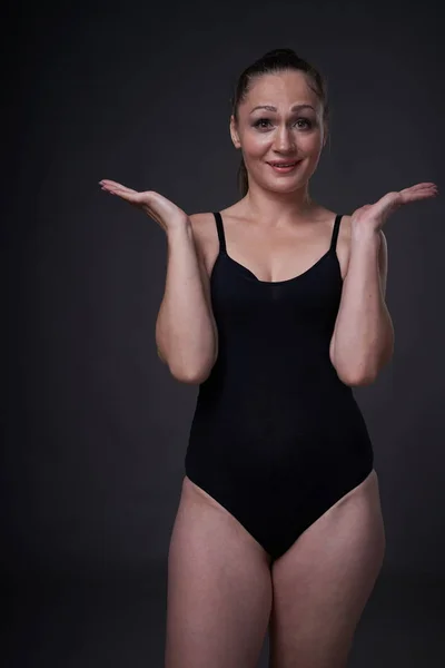 Flexibele sexy meisje poses op een zwart grijze achtergrond in de fitting kleren baud — Stockfoto