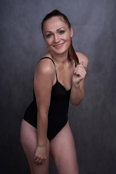 Beautiful girl in swimsuit posing against grey white background. Well-groomed skin. — Stock Photo, Image