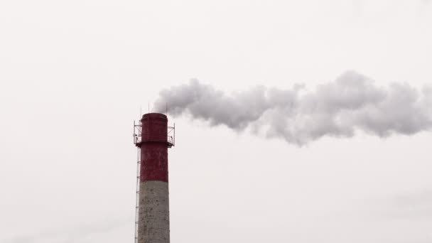 Znečištění ovzduší z průmyslových závodů. Kouřící průmyslové trubky. Červený s bílým průmyslovým komínem. — Stock video