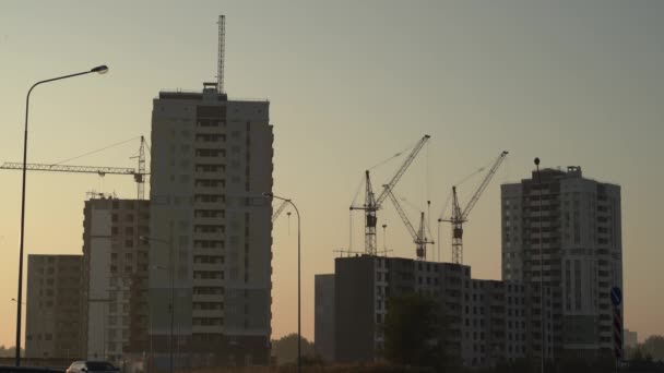 日の出の生態学的にきれいなエリア 市内の新しいアパートの建設 水平線から昇るビルタワークレーンと太陽のシルエット トーン画像 テキストのためのフリースペース — ストック動画