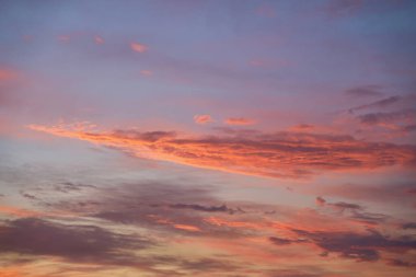 Gün batımında parlayan parlak ışık bulutlarıyla güzel bir akşam masmavi gökyüzü. Gün batımında sıcak bir yaz akşamı. Parlak gün batımı.