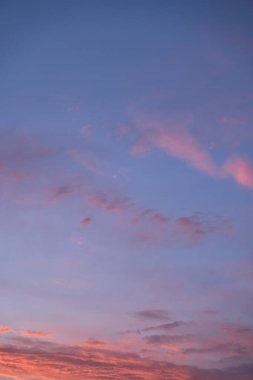 Gün batımında parlayan parlak ışık bulutlarıyla güzel bir akşam masmavi gökyüzü. Gün batımında sıcak bir yaz akşamı. Parlak gün batımı.