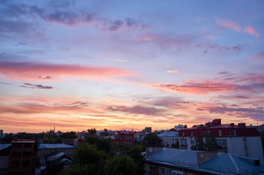 Gün batımında parlayan parlak ışık bulutlarıyla güzel bir akşam masmavi gökyüzü. Gün batımında sıcak bir yaz akşamı. Parlak gün batımı.