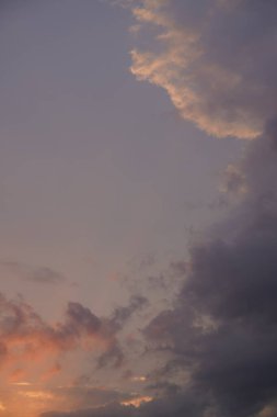 Gün batımında parlayan parlak ışık bulutlarıyla güzel bir akşam masmavi gökyüzü. Gün batımında sıcak bir yaz akşamı. Parlak gün batımı.