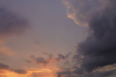 Gün batımında parlayan parlak ışık bulutlarıyla güzel bir akşam masmavi gökyüzü. Gün batımında sıcak bir yaz akşamı. Parlak gün batımı.