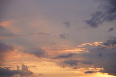Gün batımında parlayan parlak ışık bulutlarıyla güzel bir akşam masmavi gökyüzü. Gün batımında sıcak bir yaz akşamı. Parlak gün batımı.