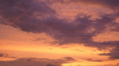 Gün batımında parlayan parlak ışık bulutlarıyla güzel bir akşam masmavi gökyüzü. Gün batımında sıcak bir yaz akşamı. Parlak gün batımı.