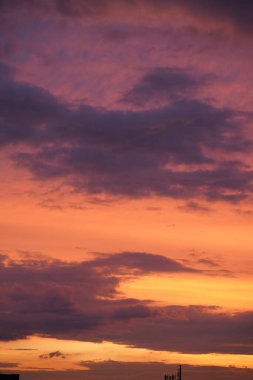 Gün batımında parlayan parlak ışık bulutlarıyla güzel bir akşam masmavi gökyüzü. Gün batımında sıcak bir yaz akşamı. Parlak gün batımı.