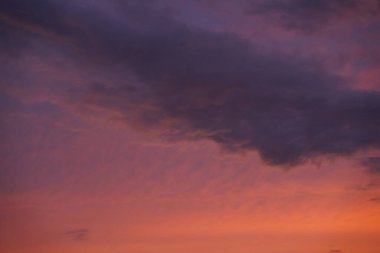 Gün batımında parlayan parlak ışık bulutlarıyla güzel bir akşam masmavi gökyüzü. Gün batımında sıcak bir yaz akşamı. Parlak gün batımı.