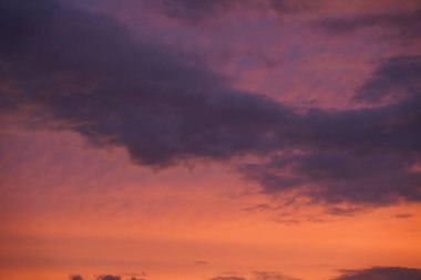 Gün batımında parlayan parlak ışık bulutlarıyla güzel bir akşam masmavi gökyüzü. Gün batımında sıcak bir yaz akşamı. Parlak gün batımı.