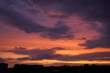Gün batımında parlayan parlak ışık bulutlarıyla güzel bir akşam masmavi gökyüzü. Gün batımında sıcak bir yaz akşamı. Parlak gün batımı.