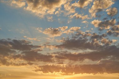 Gün batımında parlayan parlak ışık bulutlarıyla güzel bir akşam masmavi gökyüzü. Gün batımında sıcak bir yaz akşamı. Parlak gün batımı.