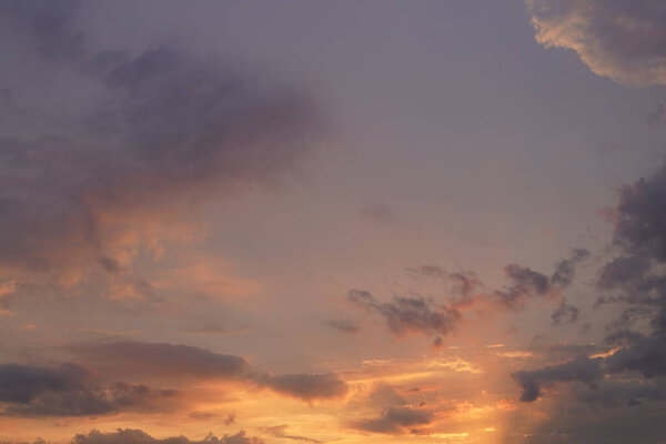 Beautiful evening blue sky at sunset with flaming bright light clouds. A warm summer evening at sunset. Bright sunset.