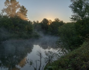 Sonbahar geldi. Nehrin üzerinde sisli, kara kara düşünen bir sis içinde şafak. Sabahın erken saatlerinde sisle kaplı güzel bir orman ve nehir manzarası. Güneş ışınları gibi. Eylül.