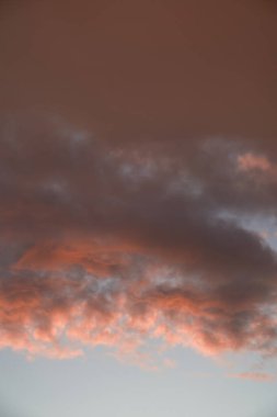 Gün batımında parlayan parlak ışık bulutlarıyla güzel bir akşam masmavi gökyüzü. Gün batımında sıcak bir yaz akşamı. Parlak gün batımı.