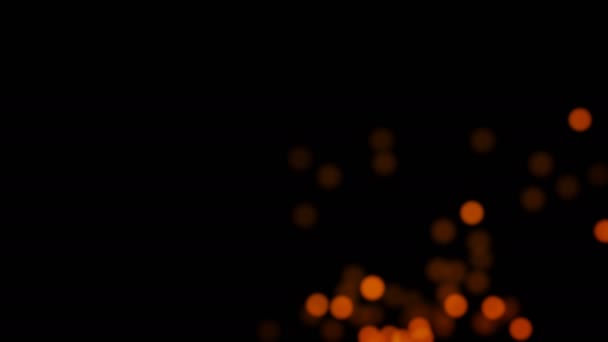 輝くぼやけた光の背景 黒い背景に金色のオレンジ色のライトと粒子の群れ — ストック動画