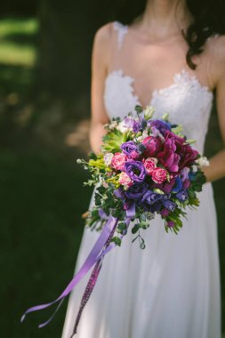 onun elinde renkli menekşe buketi Gelin