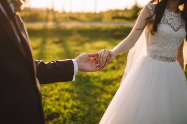 doğada düğün sırasında el ele tutuşan çift