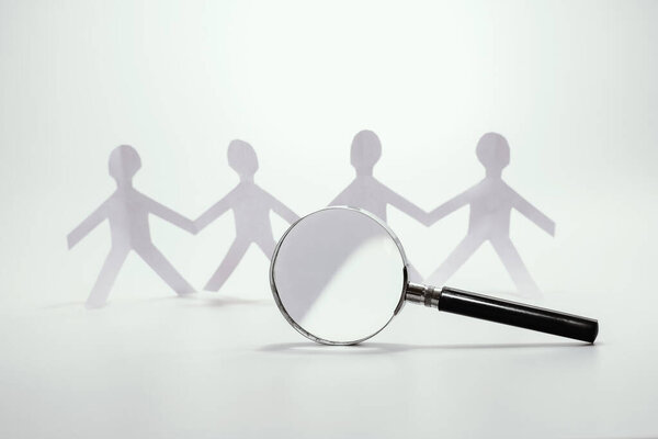 увеличительное стекло выбор бумажного символа человека, концепция найма и нахождения команды
