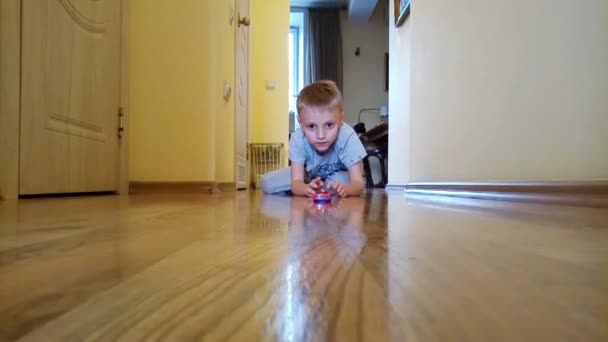 A boy plays with car on the floor — Stock Video