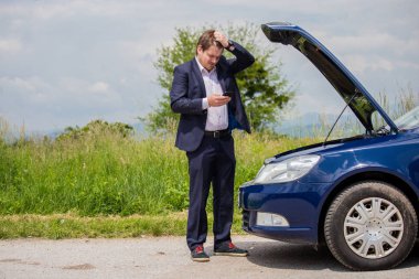 Kırık bir araba yolda sürücü kafasını, açık bir başlık, bir araba başarısızlık tutuyor