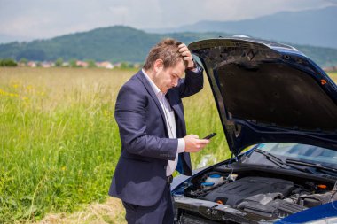 Kırık bir araba yolda sürücü kafasını, açık bir başlık, bir araba başarısızlık tutuyor