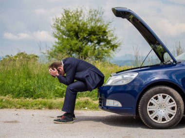 Kırık bir araba yolda sürücü kafasını, açık bir başlık, bir araba başarısızlık tutuyor