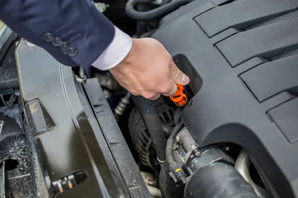 Checking the level of oil in the car\'s engine, to protect against possible car damage